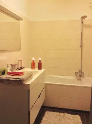 a bathroom with a tub and a sink with two candles at Welcoming Apartment with Character & Great Views in Amsterdam