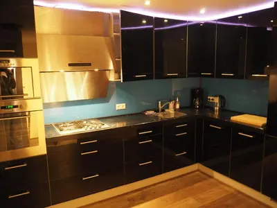 a kitchen with black cabinets and stainless steel appliances at The perfect spot in Akersloot