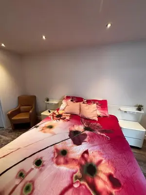 a bedroom with a large bed with flowers on it at The perfect spot in Akersloot