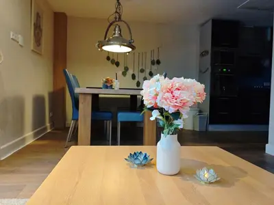 a vase with pink flowers sitting on a table at The perfect spot in Akersloot