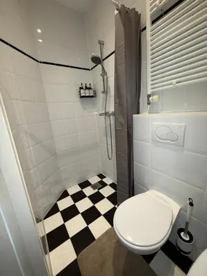 a bathroom with a toilet and a checkered floor at Manor Suite Amsterdam in Amsterdam