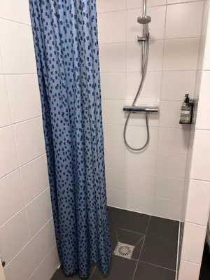 a shower with a blue shower curtain in a bathroom at Luxury Leidseplein with Private Patio in Amsterdam