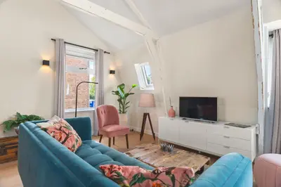 a living room with a blue couch and a tv at Abcoude city center in Abcoude