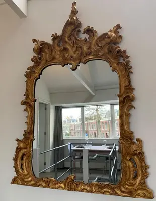 an ornate mirror in a room with a table at Abcoude city center in Abcoude