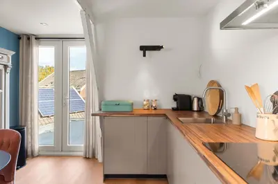 a kitchen with a counter with a sink and a window at Abcoude city center in Abcoude