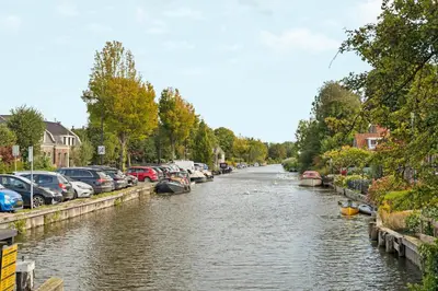 a river with cars parked on the sides of it at Abcoude city center in Abcoude