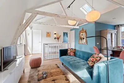 a living room with a blue couch at Abcoude city center in Abcoude
