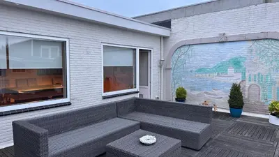 a patio with a bench and a large window at Zaanvilla in Wormerveer