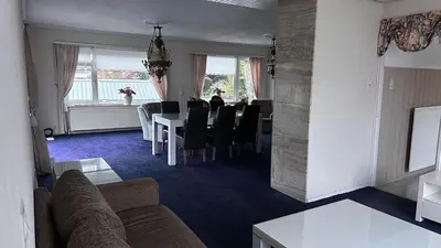 a living room with a table and a dining room at Zaanvilla in Wormerveer