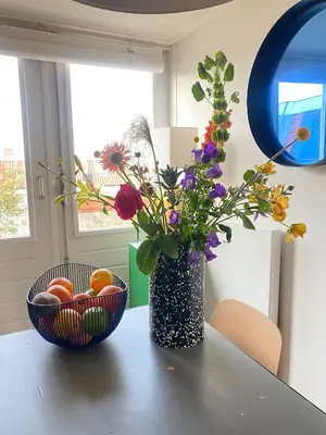 a vase filled with flowers sitting on a table at Top floor apartment at Westerpark and Jordaan in Amsterdam