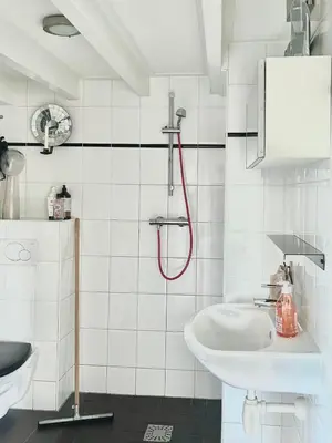 a white bathroom with a shower and a sink at Top floor apartment at Westerpark and Jordaan in Amsterdam
