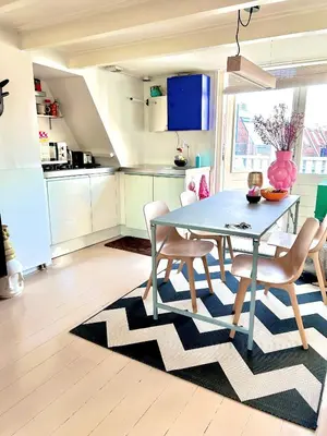 a kitchen with a dining table and chairs on a rug at Top floor apartment at Westerpark and Jordaan in Amsterdam