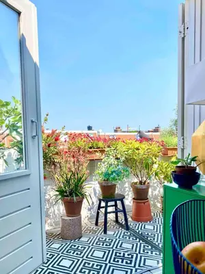 a patio with potted plants and a table on a balcony at Top floor apartment at Westerpark and Jordaan in Amsterdam