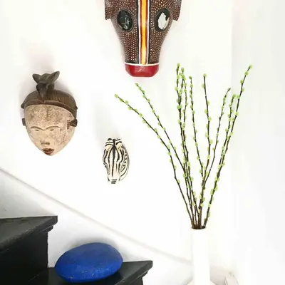 a white vase with branches in it next to a wall at Top floor apartment at Westerpark and Jordaan in Amsterdam