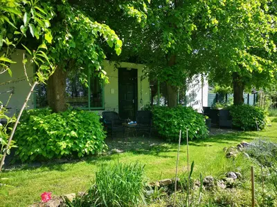 a house with a porch with trees and grass at South African lodge in Westbeemster