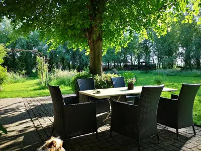 a table and chairs with a dog sitting around it at South African lodge in Westbeemster