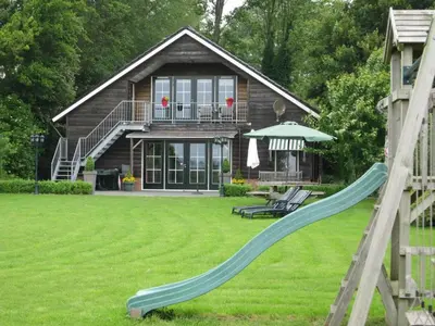 a house with a slide in the yard at Holiday Home in Noordbeemster with Bubble Bath in Noordbeemster
