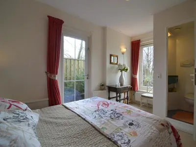 a bedroom with a bed and a bathroom with a window at Holiday Home in Noordbeemster with Bubble Bath in Noordbeemster