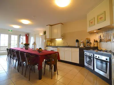 a kitchen with a table with a red table cloth at Holiday Home in Noordbeemster with Bubble Bath in Noordbeemster