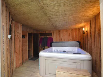 a bath tub in a room with wooden walls at Holiday Home in Noordbeemster with Bubble Bath in Noordbeemster