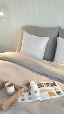 a bed with a book and a magazine on it at Little Magic Zandvoort in Zandvoort