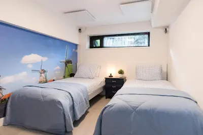 two beds in a room with a window at Pakhuis Achter - Rustig gelegen vlakbij Amsterdam & Zaanse Schans in Wormerveer