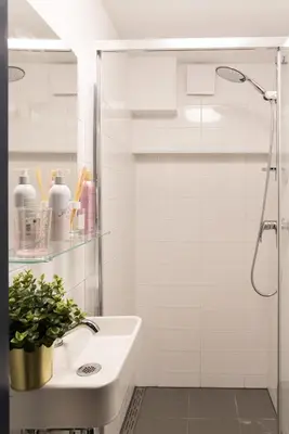 a white bathroom with a shower and a sink at Pakhuis Achter - Rustig gelegen vlakbij Amsterdam & Zaanse Schans in Wormerveer