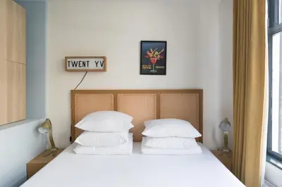 a bedroom with a bed with white sheets and pillows at Herenstraat Residence in Amsterdam