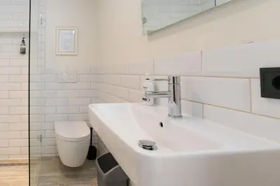 a white bathroom with a sink and a toilet at Herenstraat Residence in Amsterdam