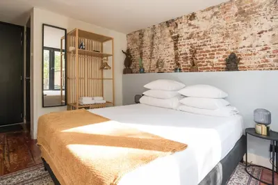 a bedroom with a white bed with a brick wall at Herenstraat Residence in Amsterdam