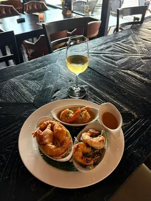 a plate of shrimp and a glass of wine on a table at Provence Driehuis Apartment in Driehuis