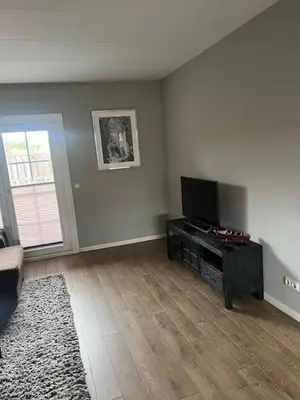 an empty living room with a flat screen tv at Provence Driehuis Apartment in Driehuis