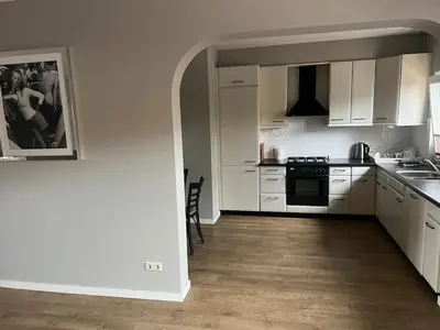a kitchen with white cabinets and a stove top oven at Provence Driehuis Apartment in Driehuis