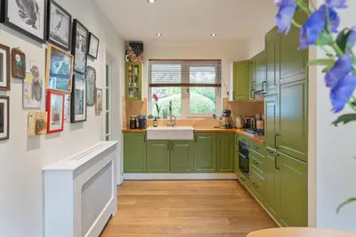 a kitchen with green cabinets and a sink at The Green Oasis charming family villa with garden and private parking in Zandvoort