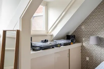 a attic room with a counter with a window at The Green Oasis charming family villa with garden and private parking in Zandvoort