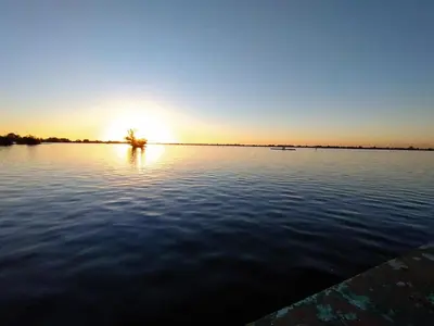 a sunset over a large body of water at Floating holiday home close to AMS
