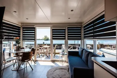 a living room with a blue couch and a table at Floating holiday home close to AMS