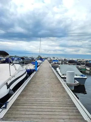 a wooden dock with boats docked in the water at Floating holiday home close to AMS