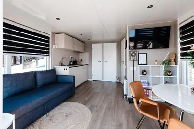 a living room with a couch and a table at Floating holiday home close to AMS
