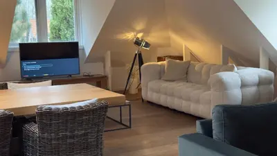 a living room with a couch and a table at Loft 55 Bergen-Schoorl Luxury Appartement 165m2 in Schoorl