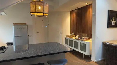 a kitchen with a counter top and a refrigerator at Loft 55 Bergen-Schoorl Luxury Appartement 165m2 in Schoorl