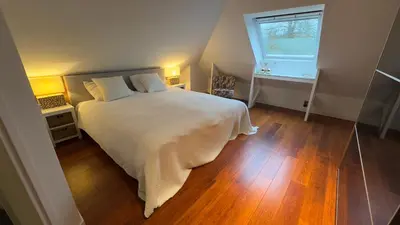 a bedroom with a large white bed and a window at Loft 55 Bergen-Schoorl Luxury Appartement 165m2 in Schoorl