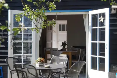 an open patio door with a table and chairs at Hortensia Eiland in Zegveld