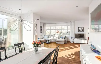 a white living room with a table and a couch at Light-flooded villa in Bergen aan Zee