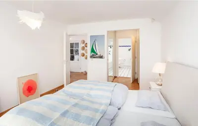 a white bedroom with a bed in a room at Light-flooded villa in Bergen aan Zee
