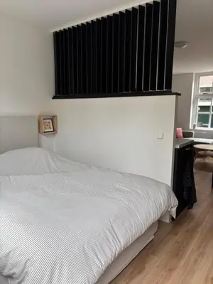 a bedroom with a white bed and a window at Studio Fnidsen in Alkmaar