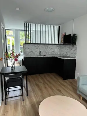 a living room with a table and a couch at Studio Fnidsen in Alkmaar