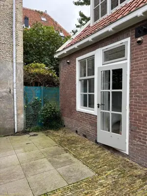 a brick house with a white door and window at Studio Fnidsen in Alkmaar