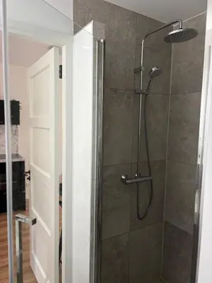 a shower with a glass door in a bathroom at Studio Fnidsen in Alkmaar