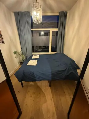 a bedroom with a blue bed in a room with a window at Cozy apartment in Utrecht in Utrecht